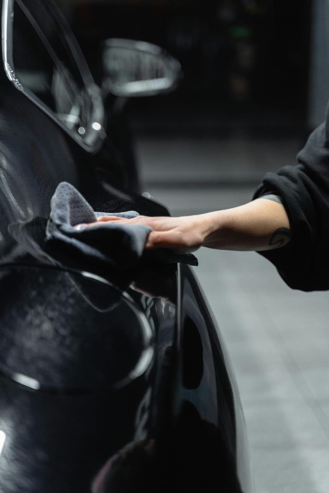 "Premier Detailing expert hand-wiping the exterior of a car under the window, highlighting our meticulous mobile detailing services in West Plains, MO."