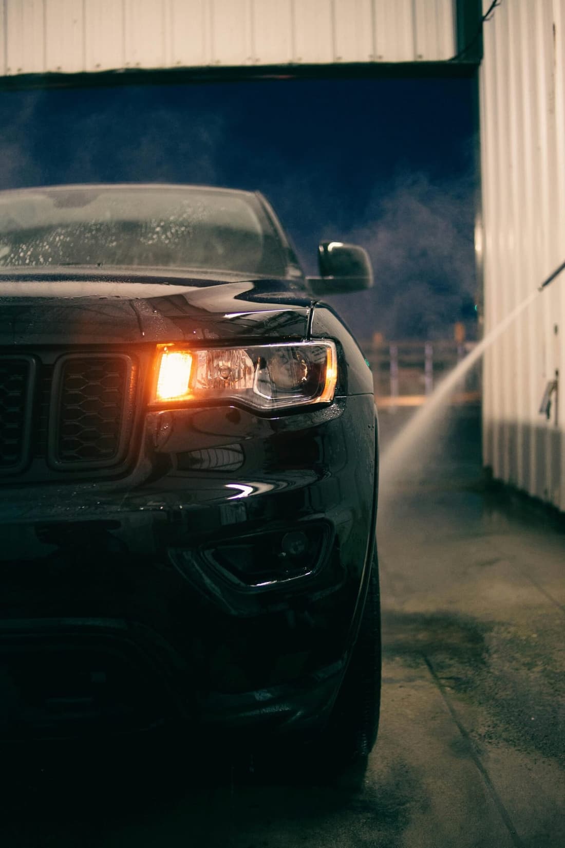 Black SUV being professionally washed at night at Premier Detailing in West Plains, MO.