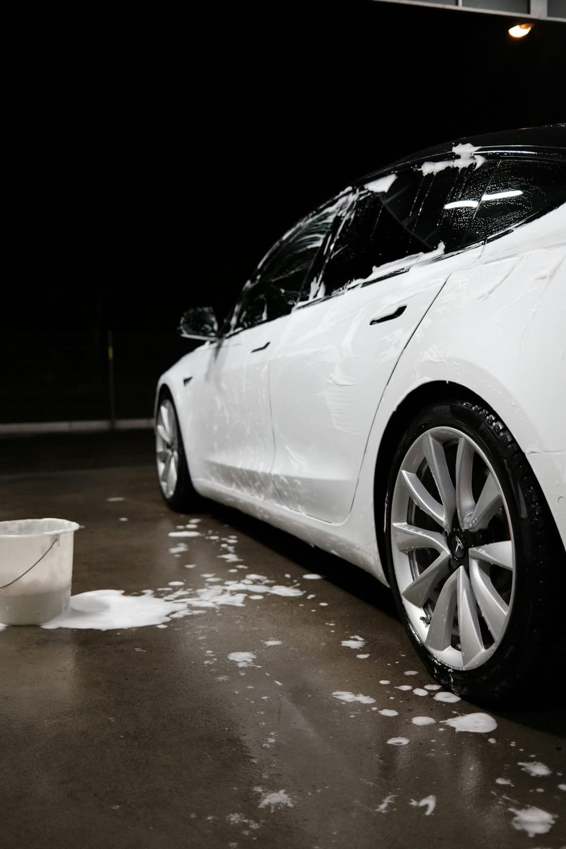 "Professional car detailing in West Plains, MO: Bottom side view of a car covered in car shampoo by Premier Detailing, showcasing expert car cleaning services to avoid common mistakes."