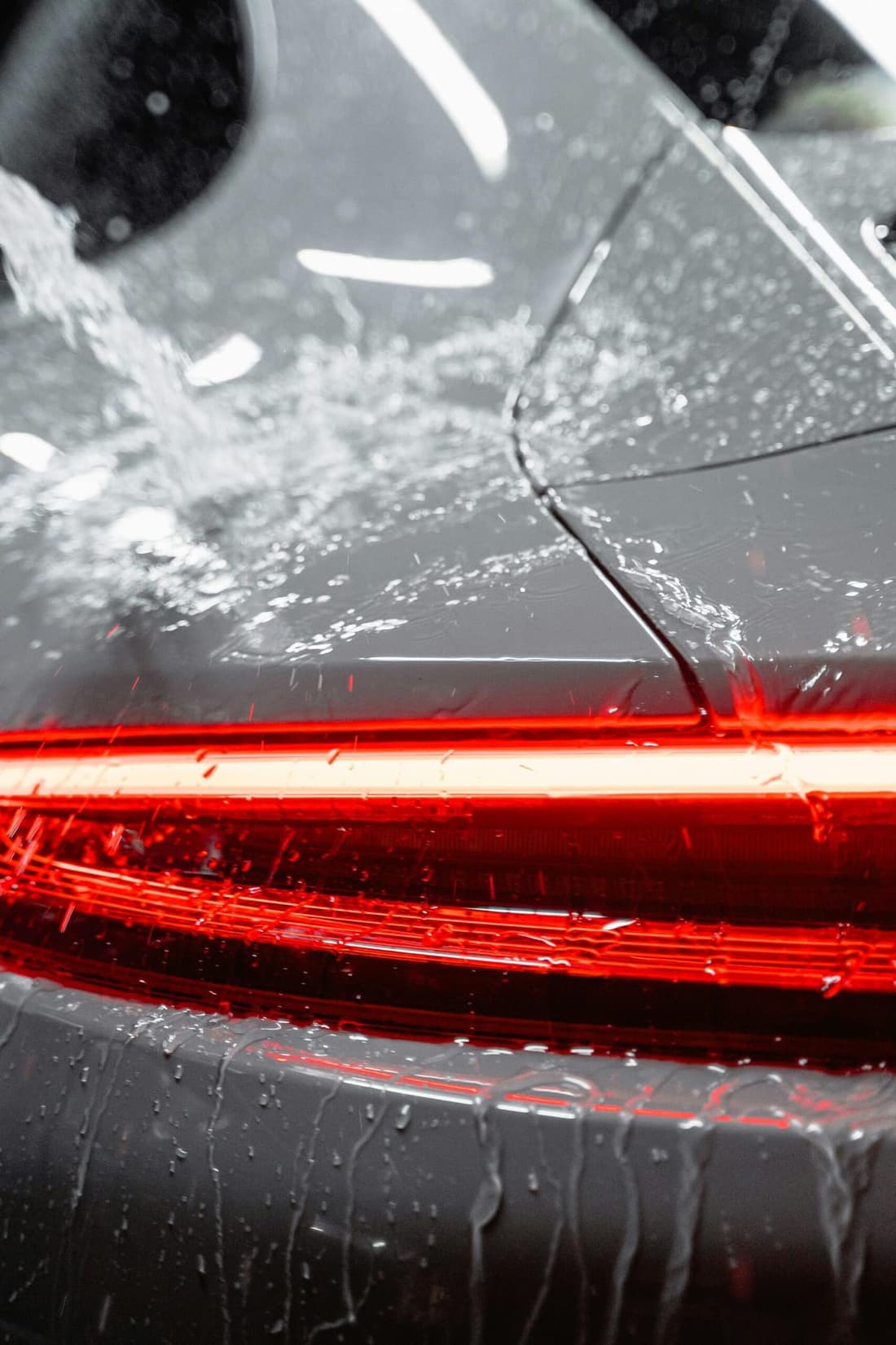 "Water cascading over a Porsche taillight, showcasing Premier Detailing’s expert care and protective services in West Plains, MO."